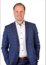 Portret van een lachende man in een blauw geruit colbert